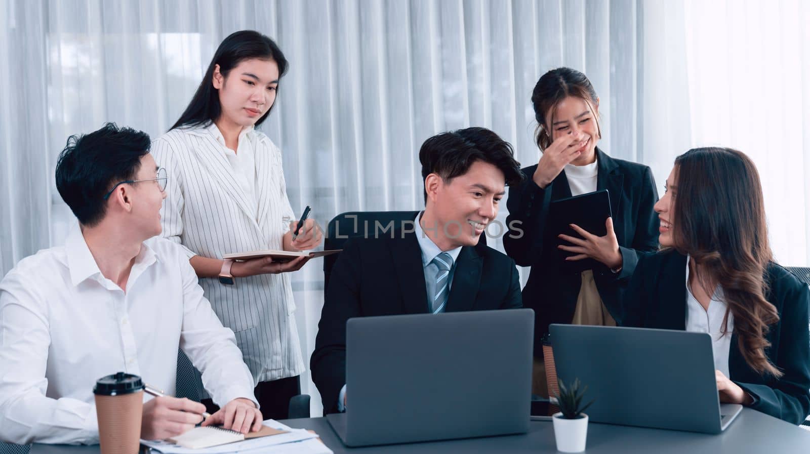 Harmony in office concept as business people analyzing dashboard paper together in workplace. Young colleagues give ideas at manager desk for discussion or strategy planning about project.