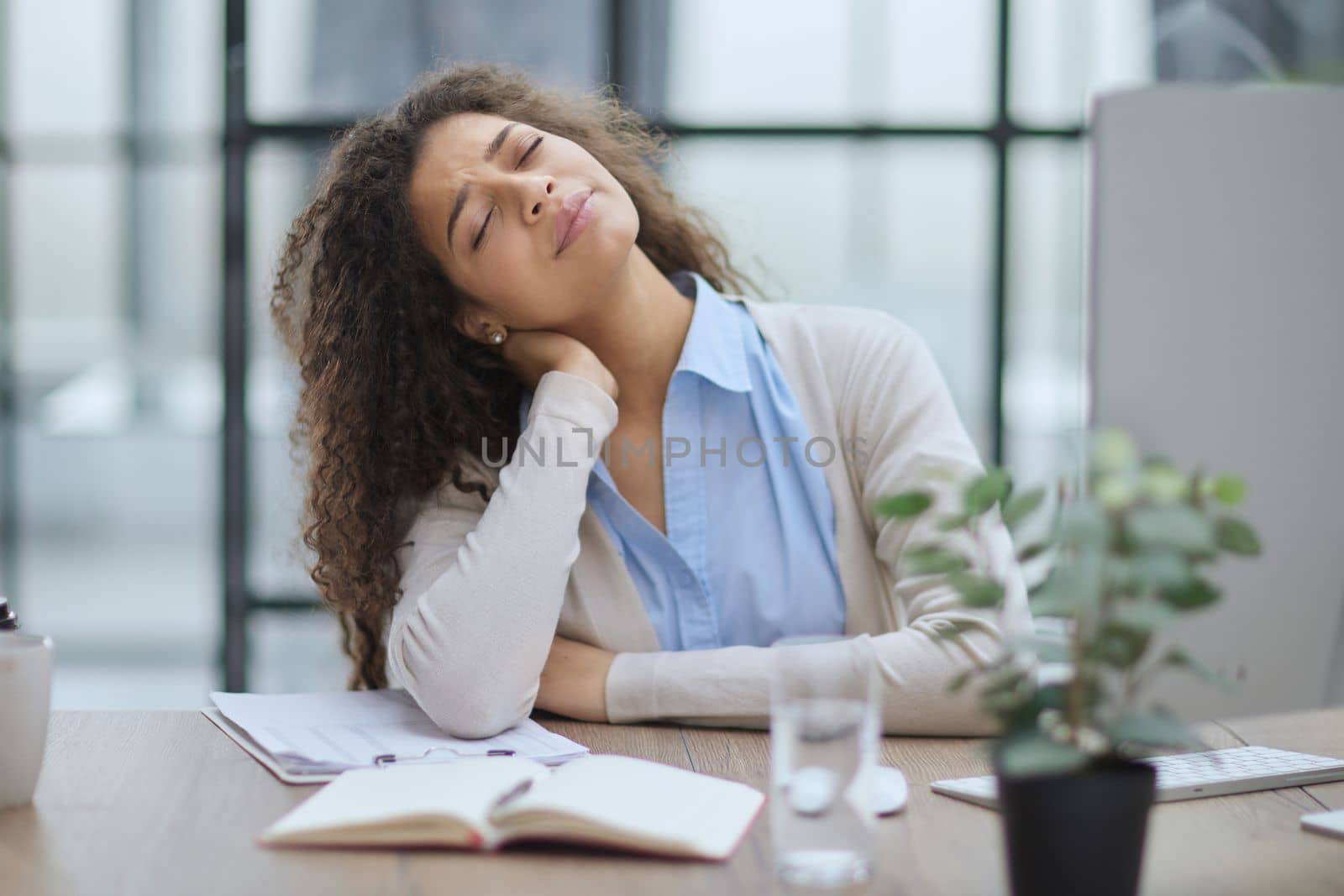 Businesswoman with headache sitting at the table in the office