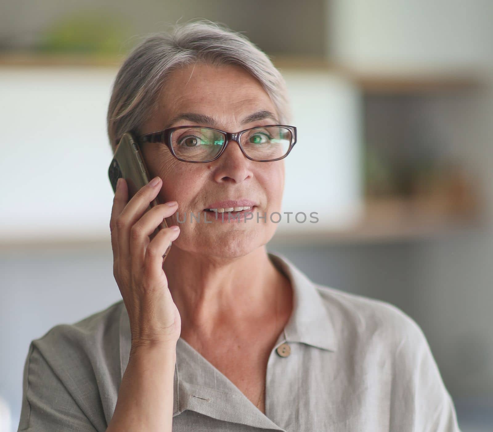 mature woman calling on the phone in the office.