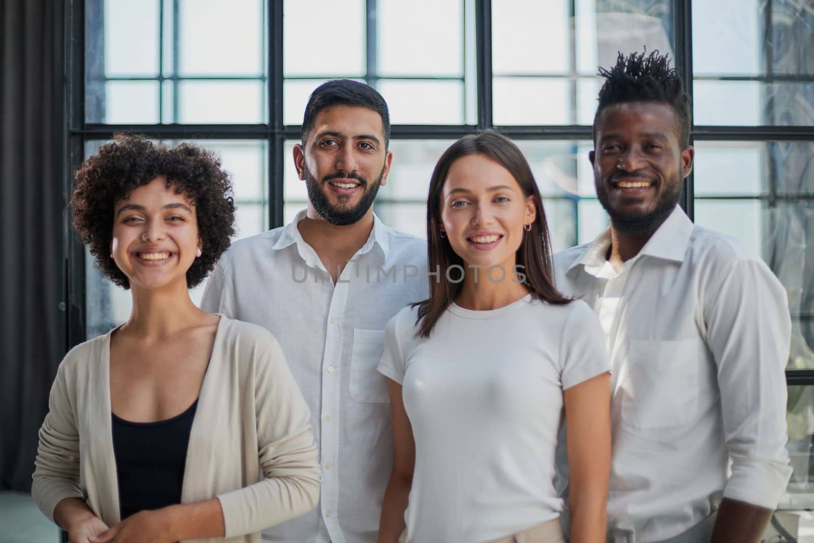 Portrait of successful creative business team looking at camera and smiling. Diverse business people standing together at startup.
