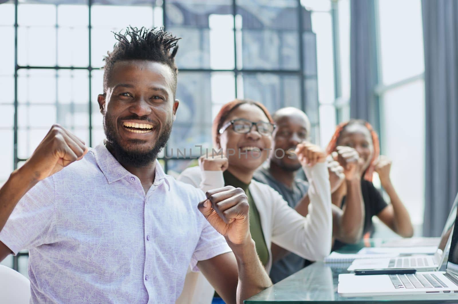 Happy young African-American man and his team in background