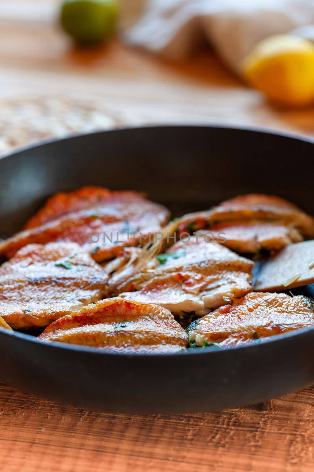 red mullet fish cooked on a pan, side view, selective focus