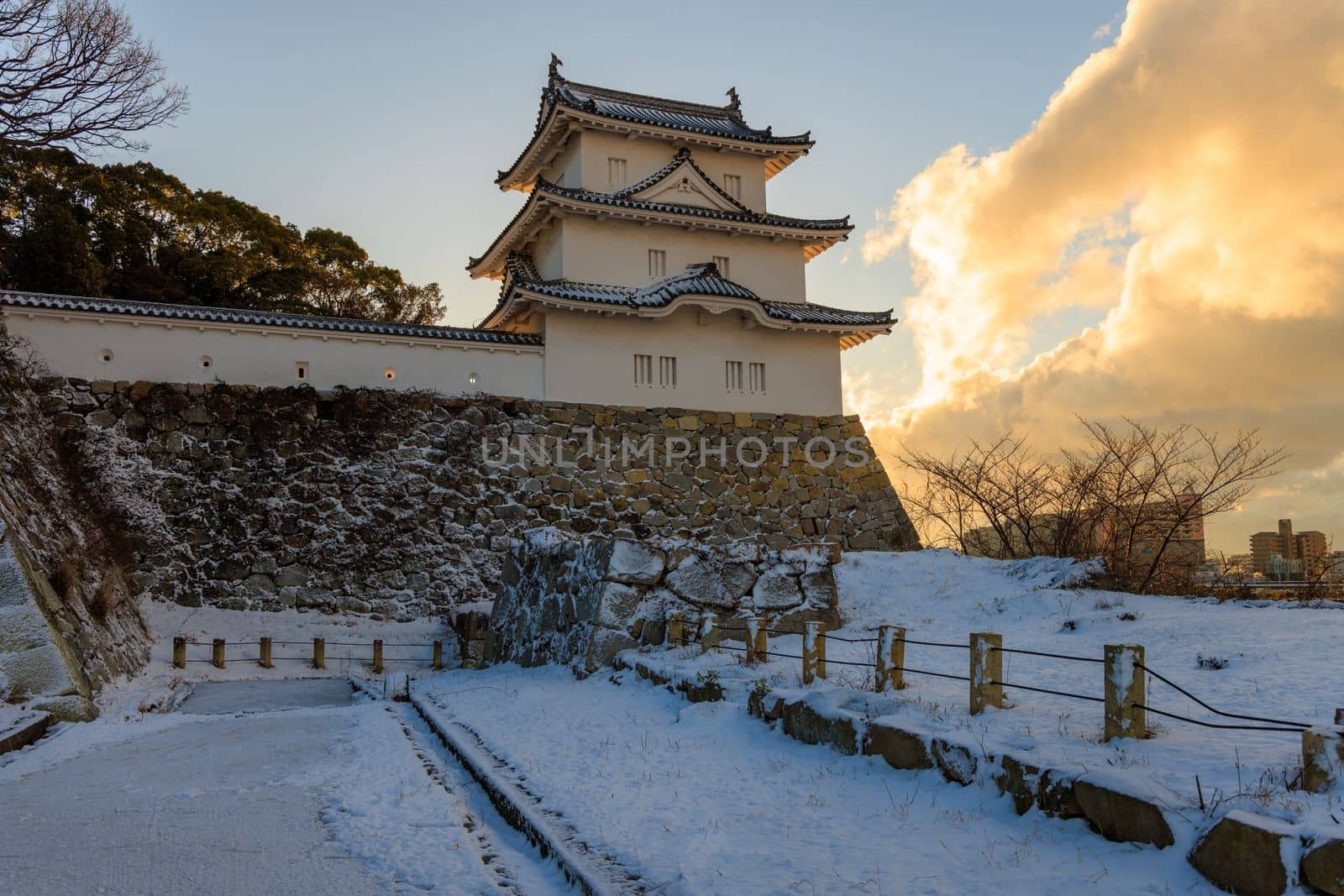 Akashi Castle tower and stone walls in snowy landscape at sunrise. High quality photo