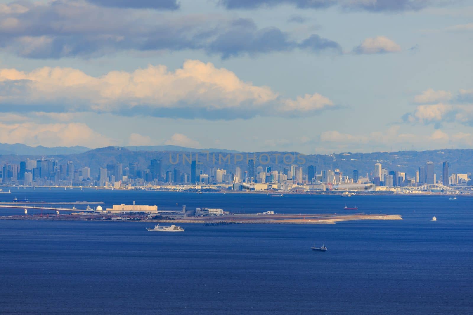 Kobe Airport on Manmade Island at Sea Level with City Skyline in Distance by Osaze