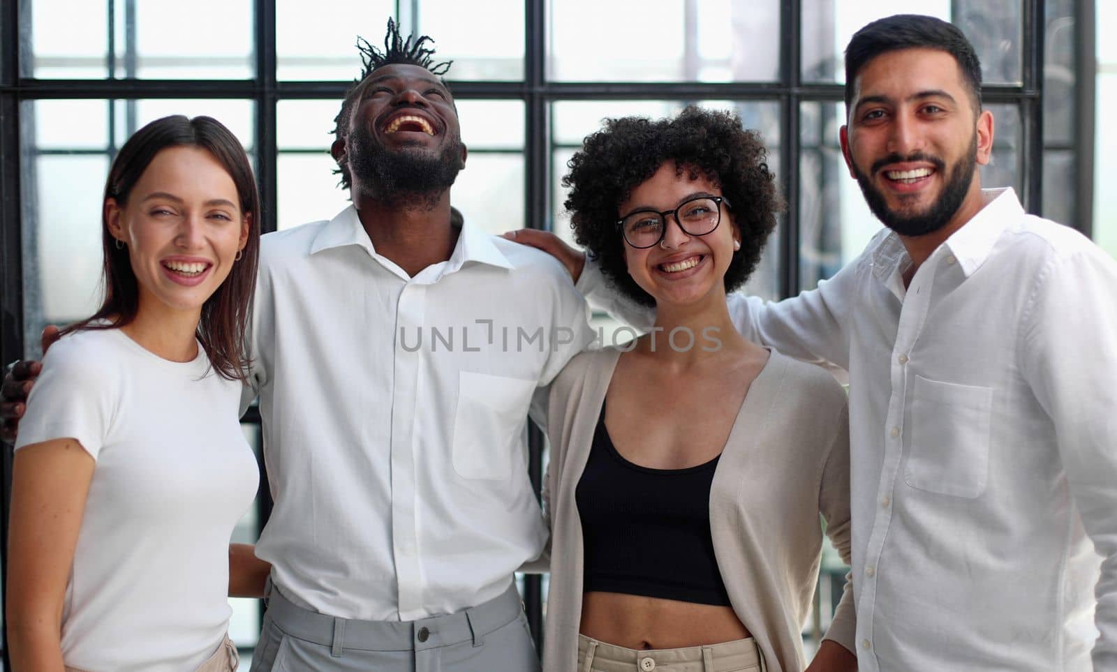 Portrait of successful creative business team looking at camera and smiling. Diverse business people standing together at startup.