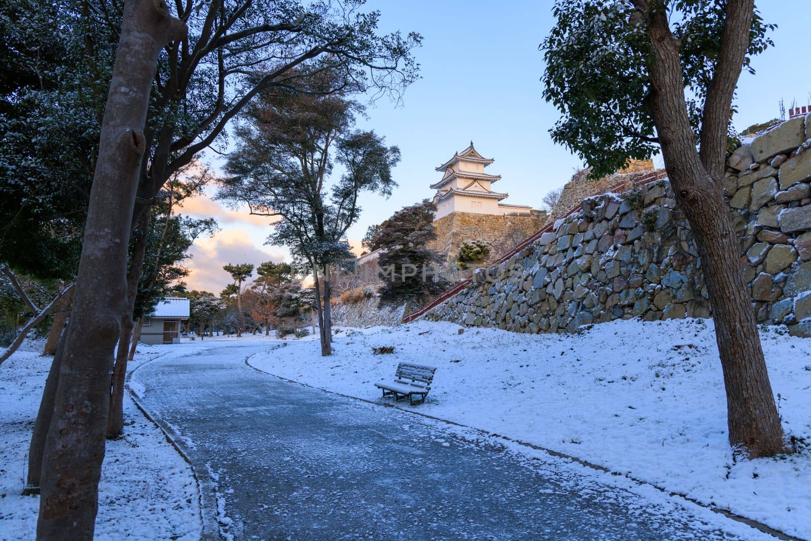 Path in snow through Akashi Castle Park on quiet winter morning by Osaze