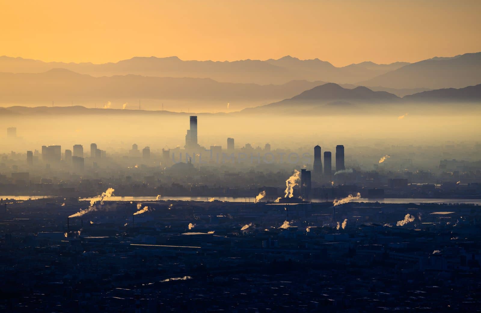 Thick layer of haze over industrial city at sunrise by Osaze