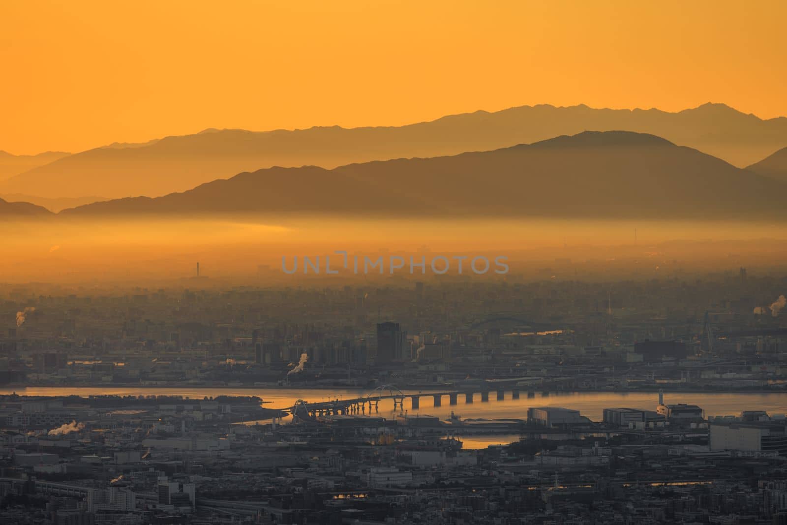 Thick layer of smog over industrial city with orange glow in sky at dawn. High quality photo