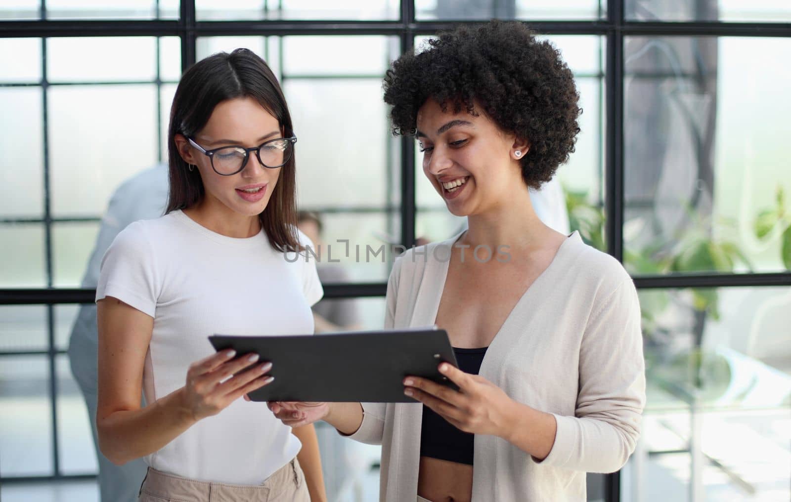 Two women analyzing documents office. Woman executives at work in office discussing some paperwork. by Prosto