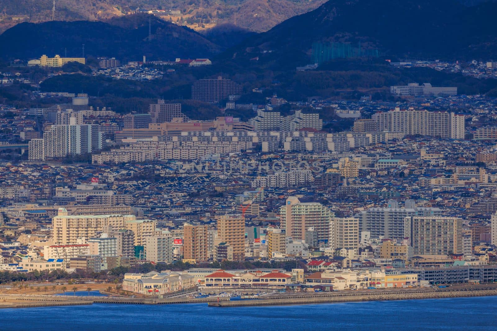 Multi-story residential apartments in sprawling hillside city on coast. High quality photo