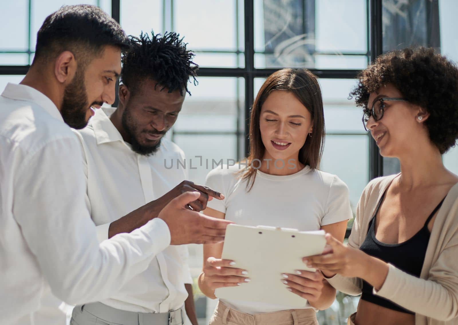 Happy young female employee discussing online project, showing computer presentation to skilled team leader in eyeglasses. Friendly diverse colleagues working in pairs on laptop, using applications.