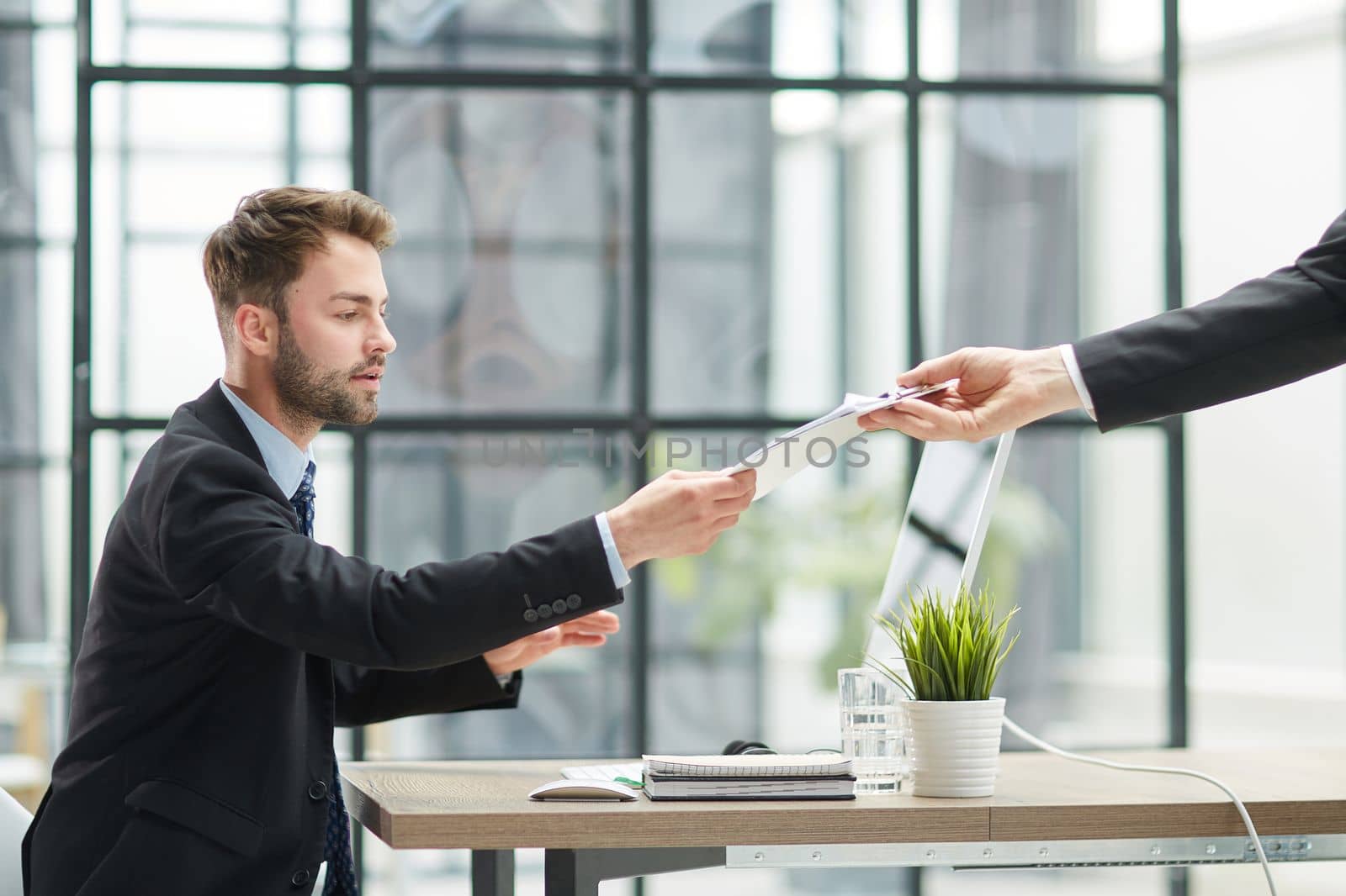 Businessman Taking Papers From Secretary In Office