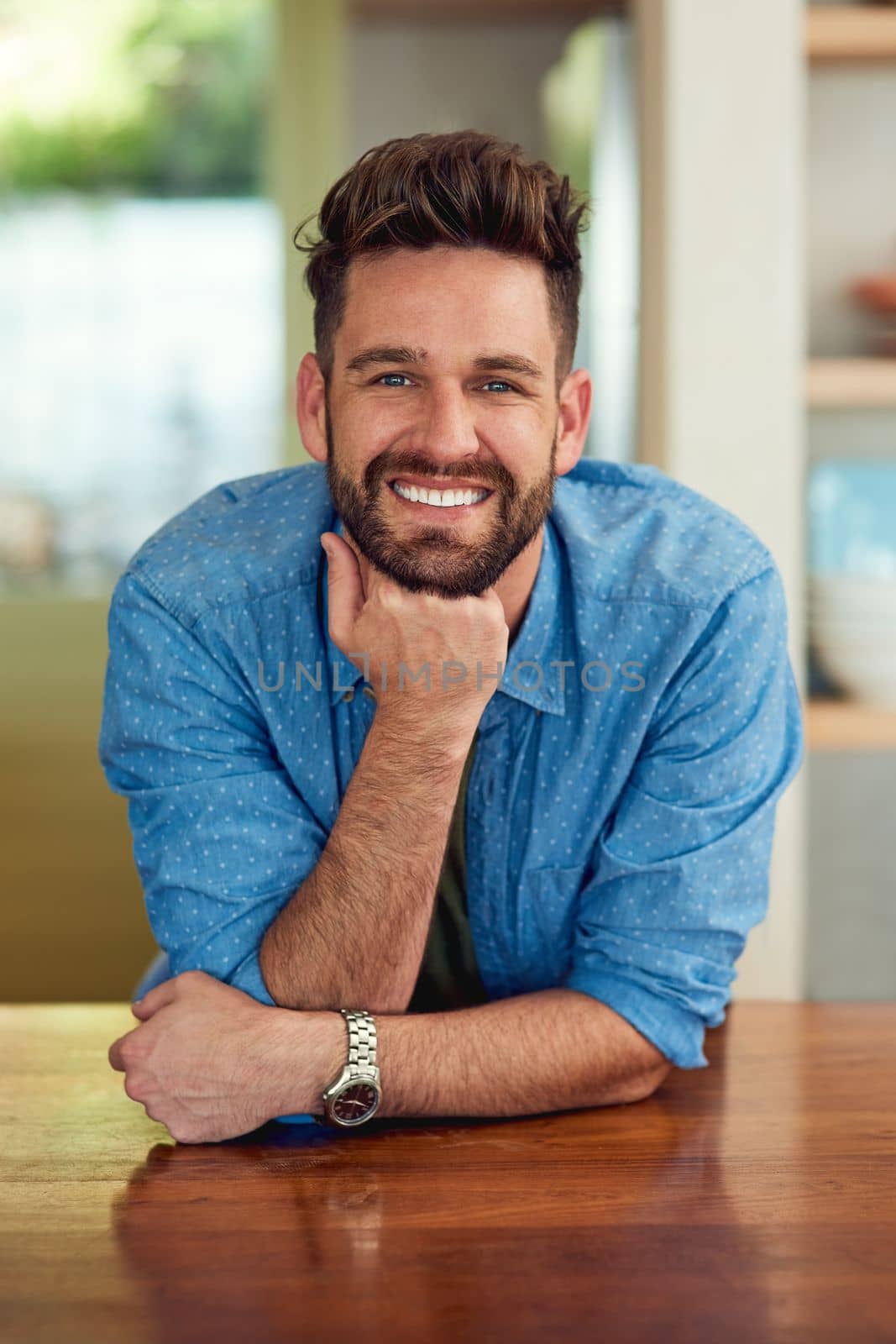 My lifestyle is conducive to my happiness. Portrait of a happy man leaning against a counter at home