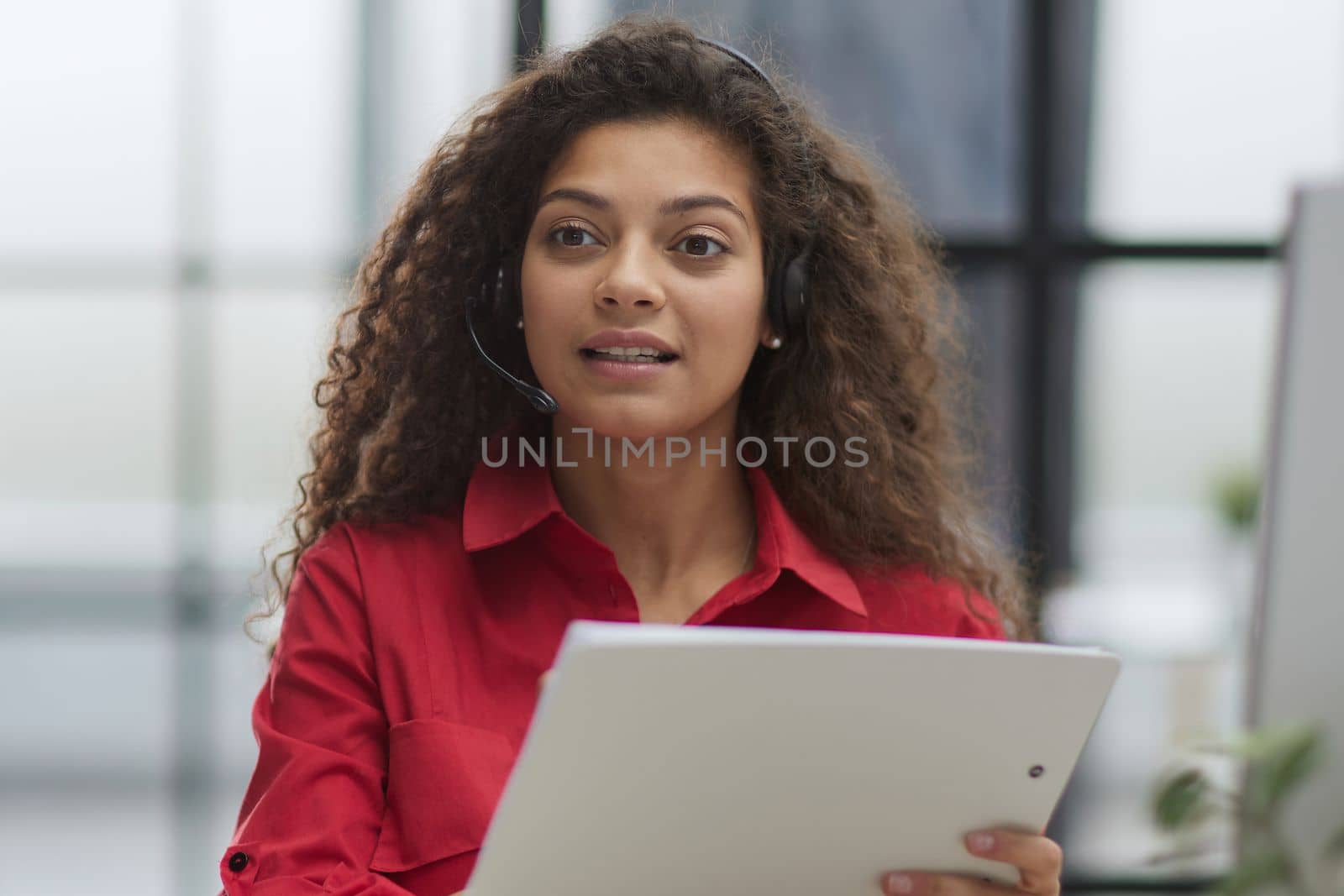 Attractive young business woman, writing notes to notebook at her workplace in office.