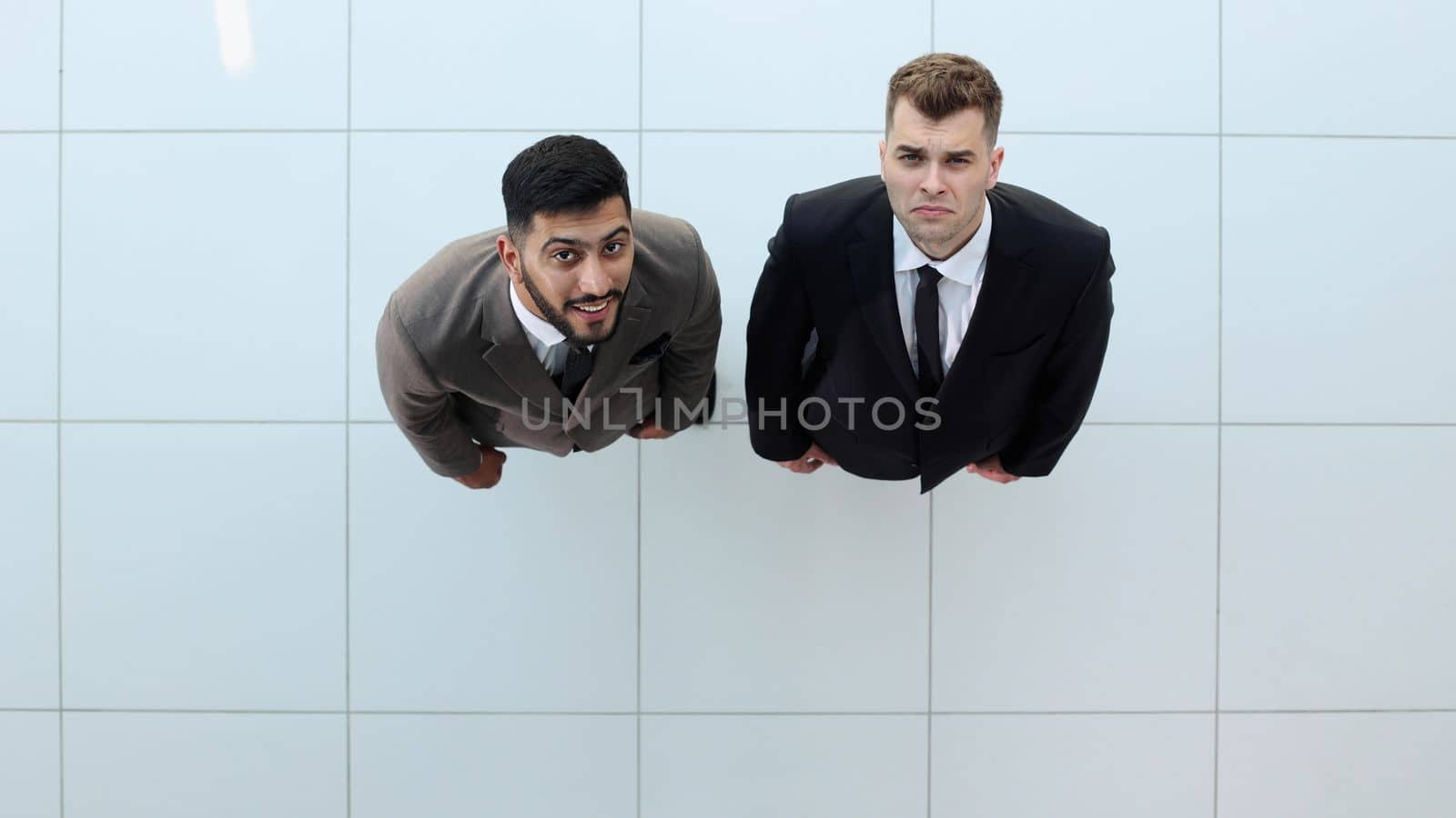 Portrait of two concentrated businessmen partners dressed in formal suit walking and having conversation during working meeting