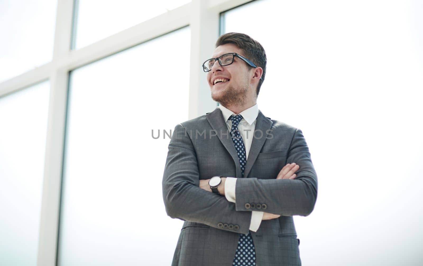 Portrait of a young businessman wearing glasses and standing in office