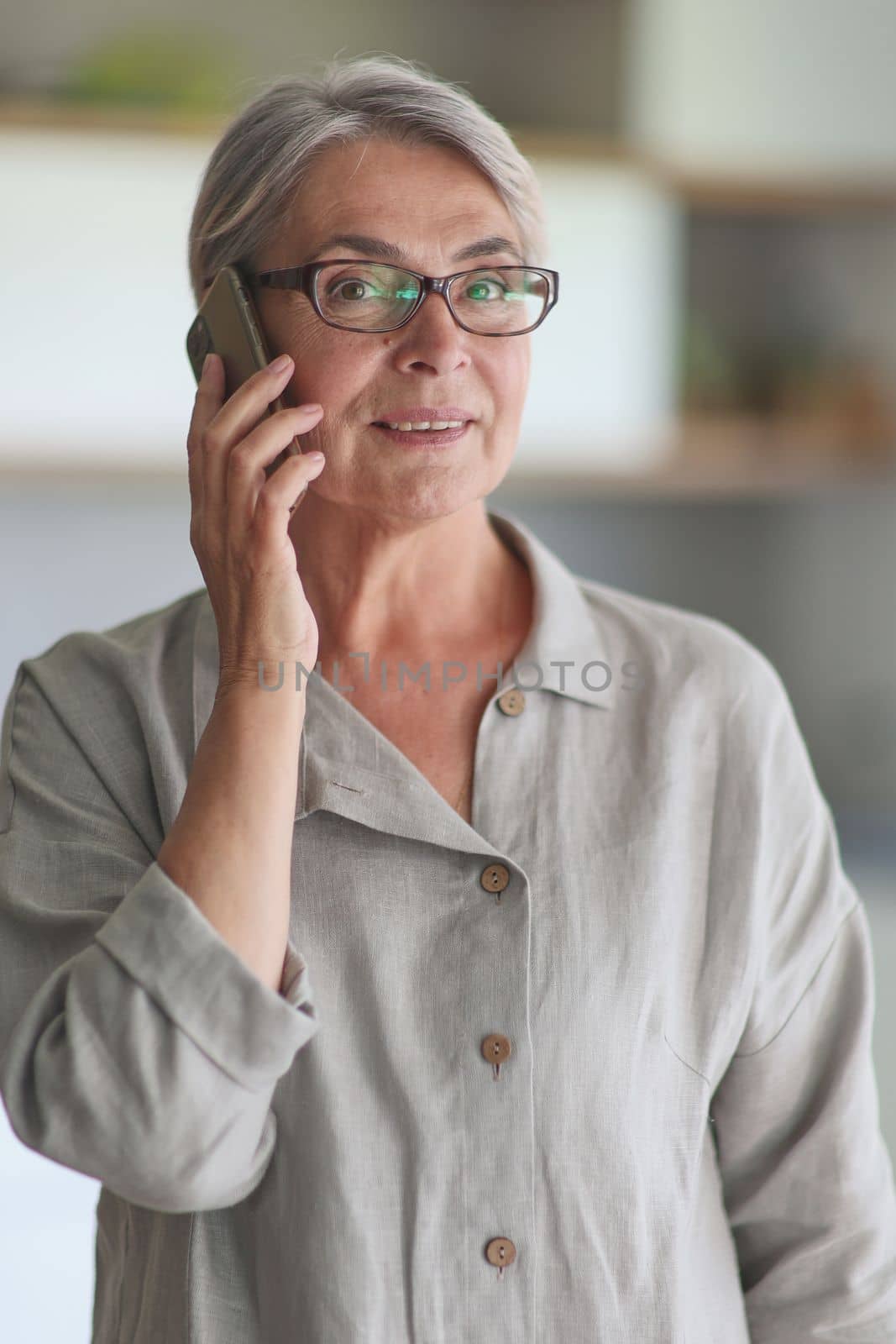 mature woman calling on the phone in the office.