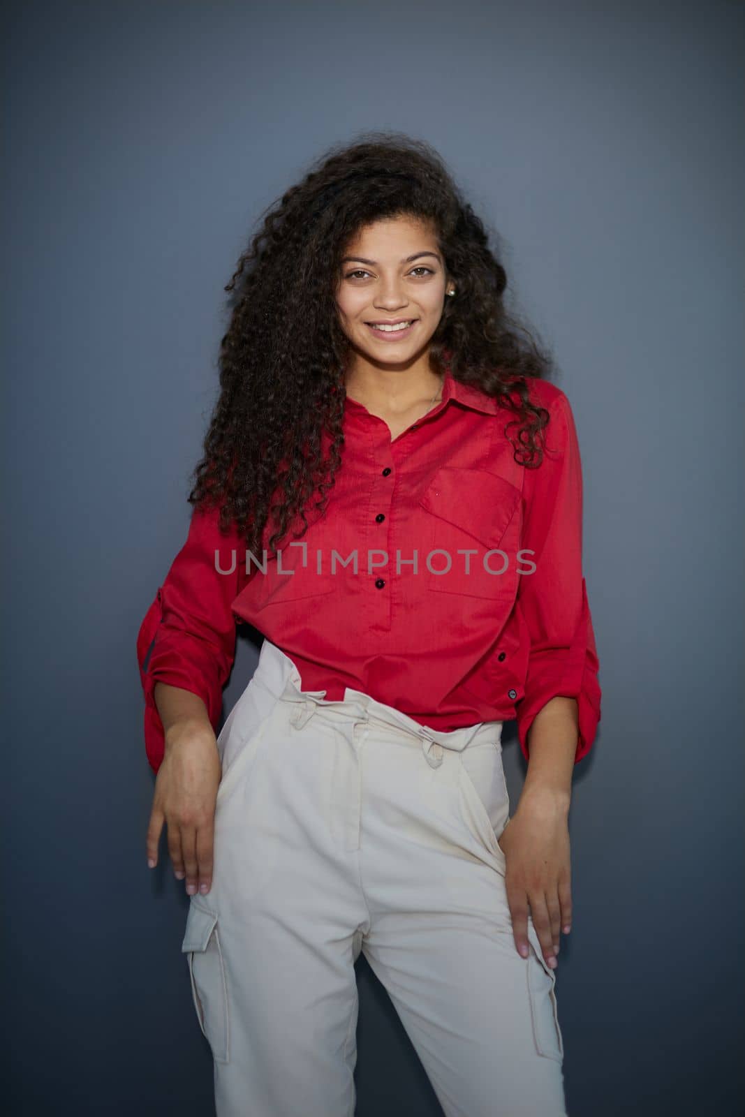 Happy young business woman posing isolated over grey wall background.