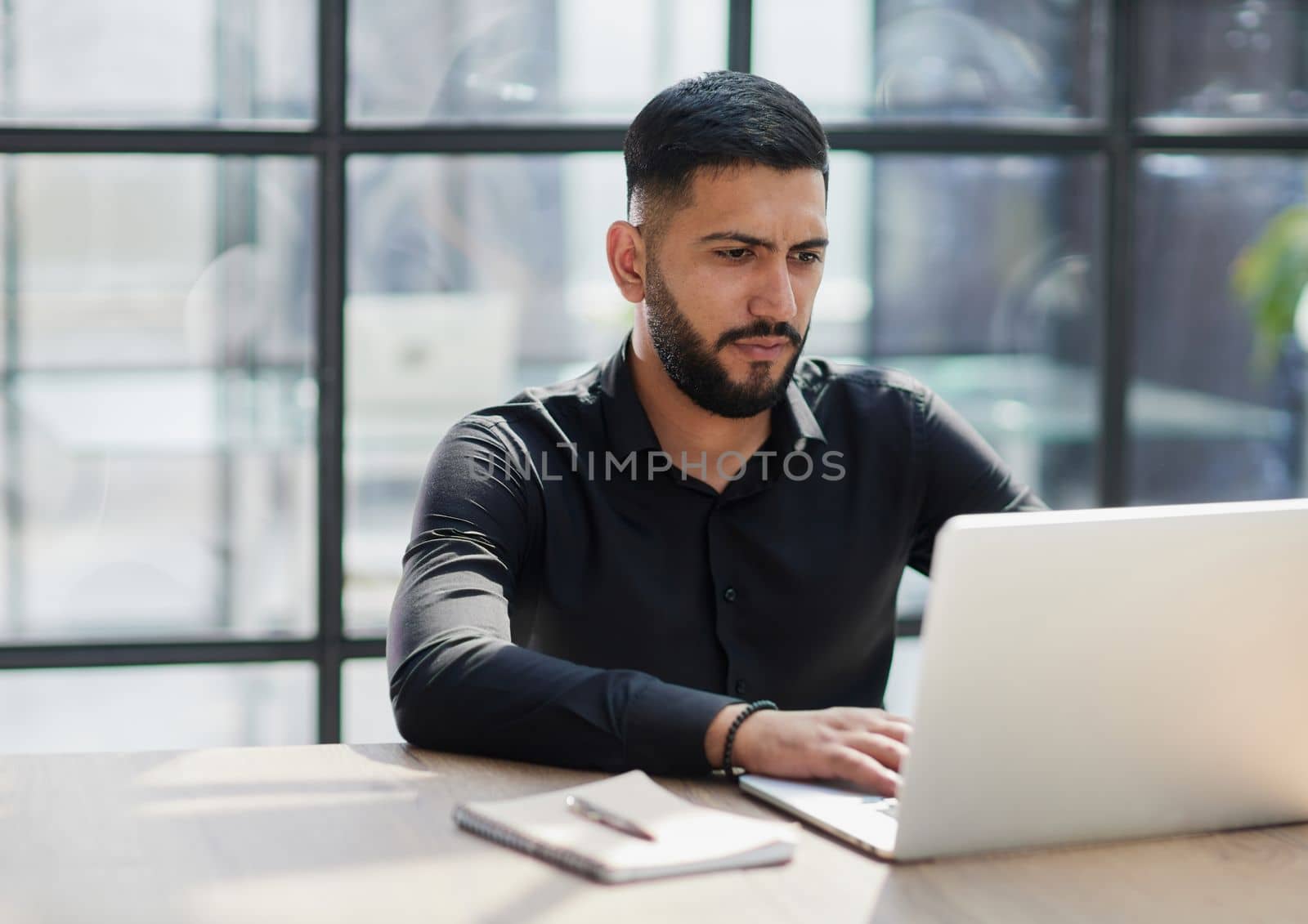 Bearded young businessman working on modern office.