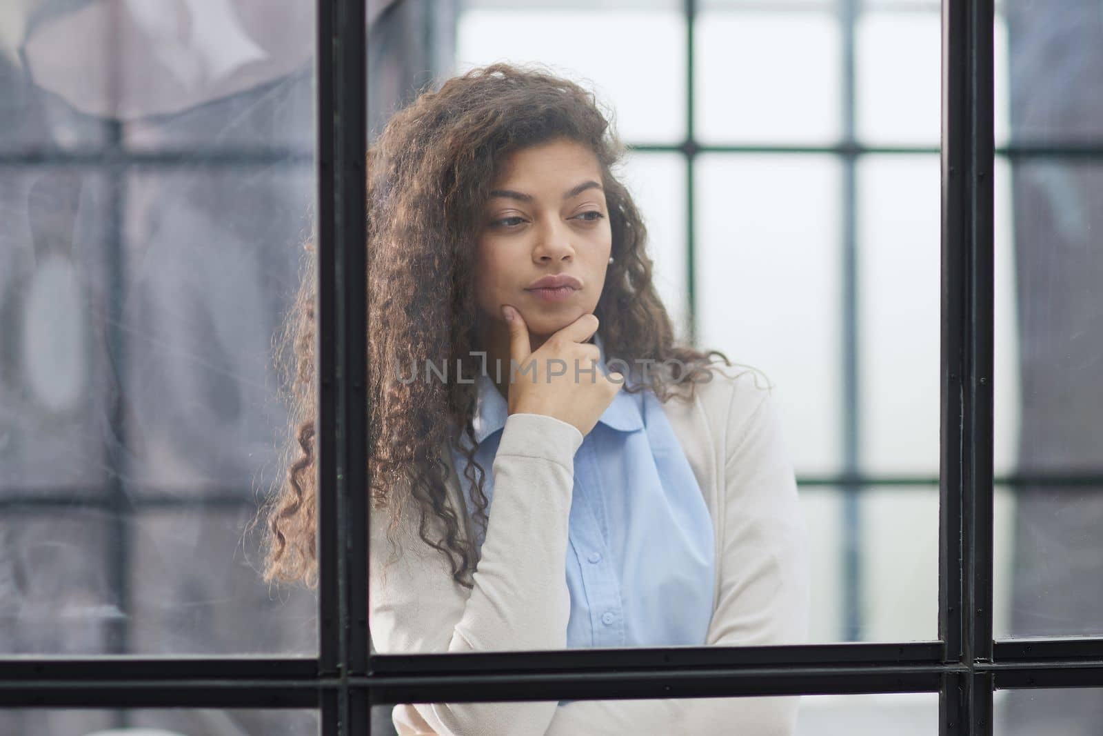 from behind the glass. young business woman thinking about something