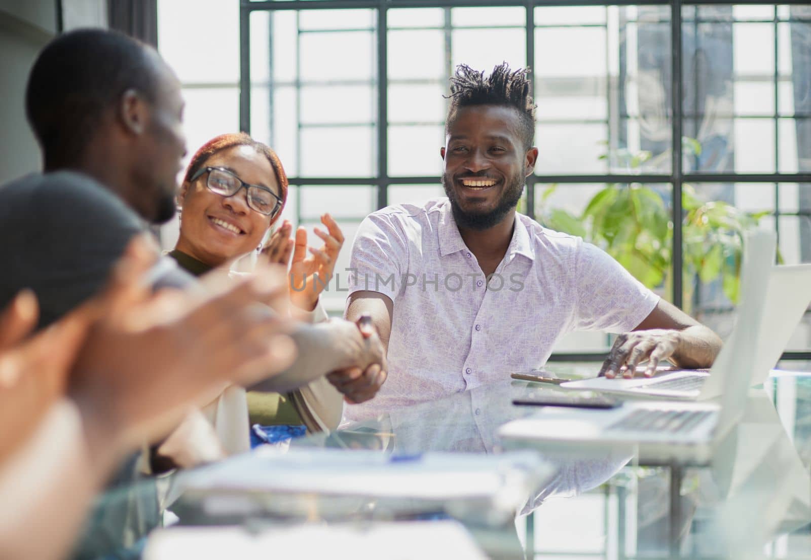 team of young african people in the office shaking hands