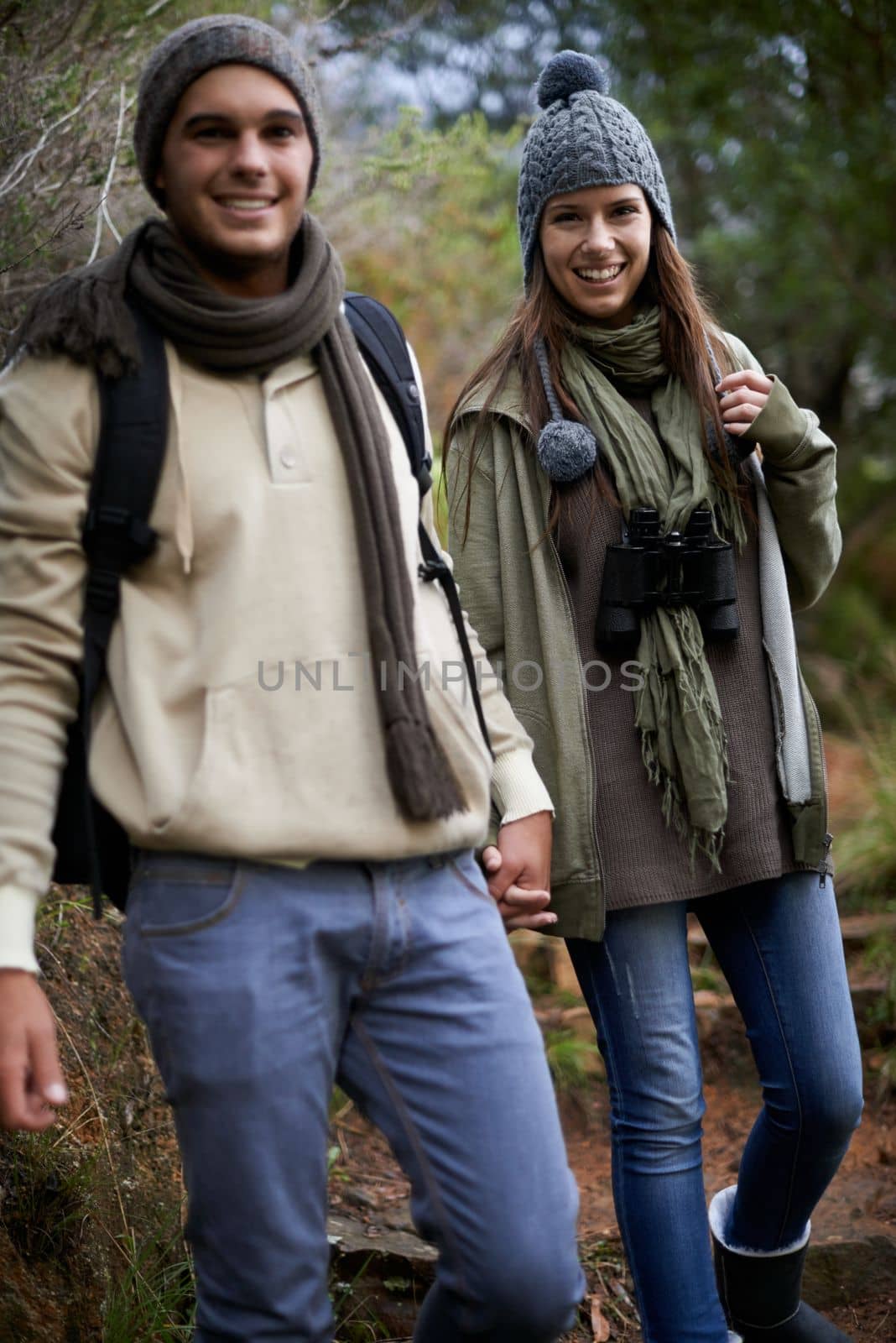 They love nature. A happy young couple spending time together outdoors. by YuriArcurs