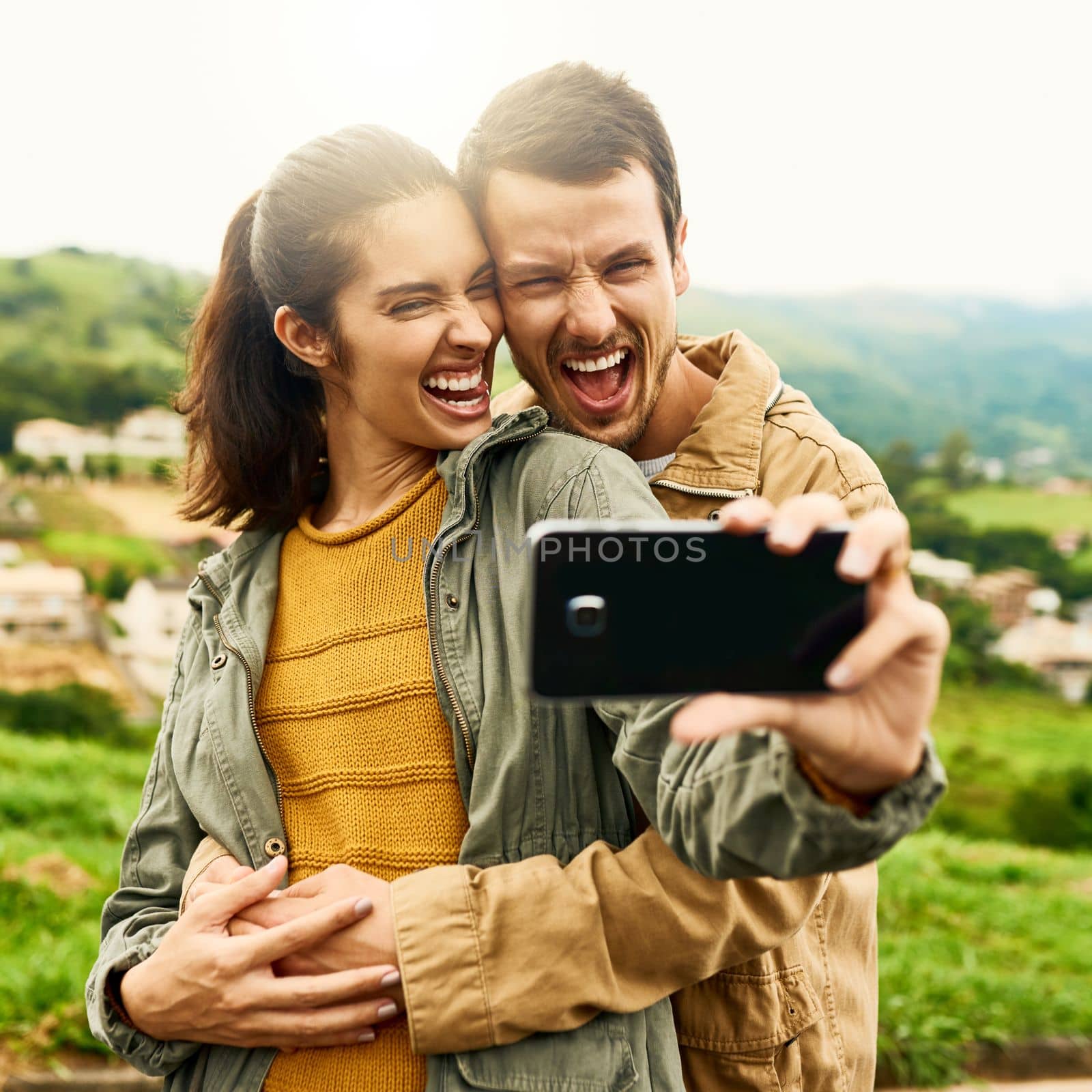 Find the person who brings out the best in you. a loving couple taking a selfie outdoors. by YuriArcurs