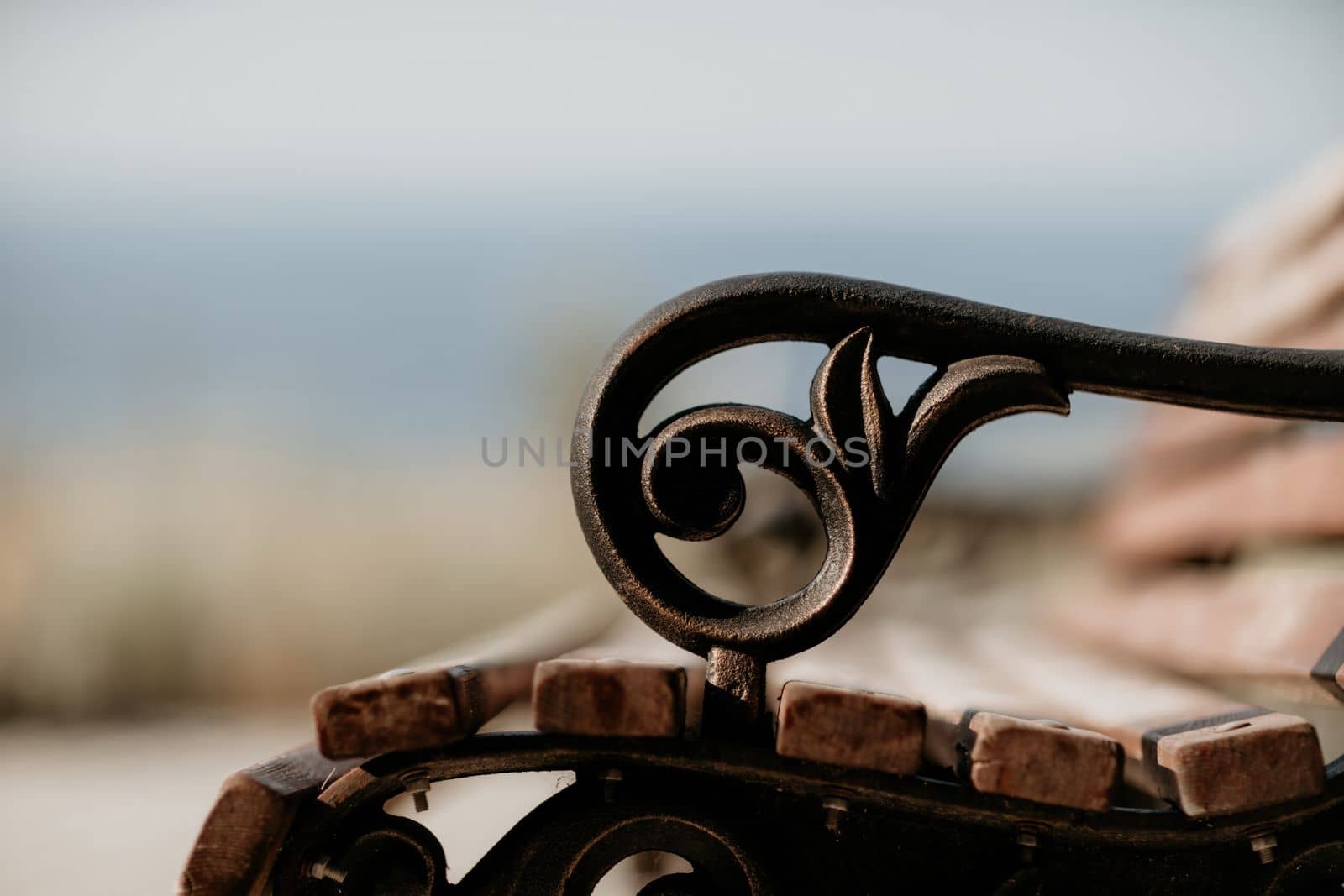 Empty Park wooden bench Closeup view. Wood exterior material. Wood material details. Blank Old bench in a shady area of the garden or the park,outdoor. Shaded wood park bench surrounded by greenery