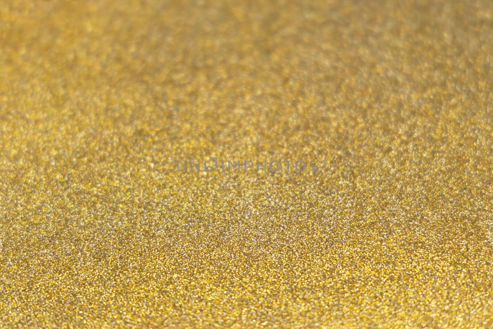 Golden shiny glitter paper texture. Shining luxurious fabric. Glimmering golden christmas background