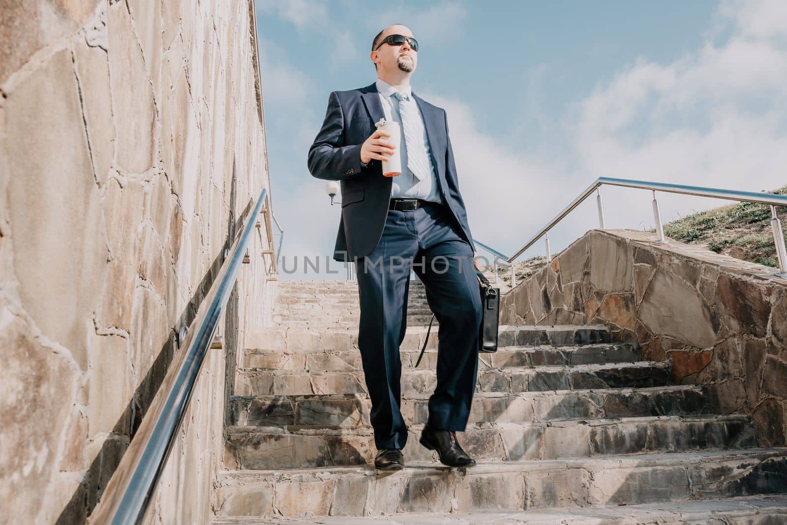 Business executive with briefcase going down the stairs.