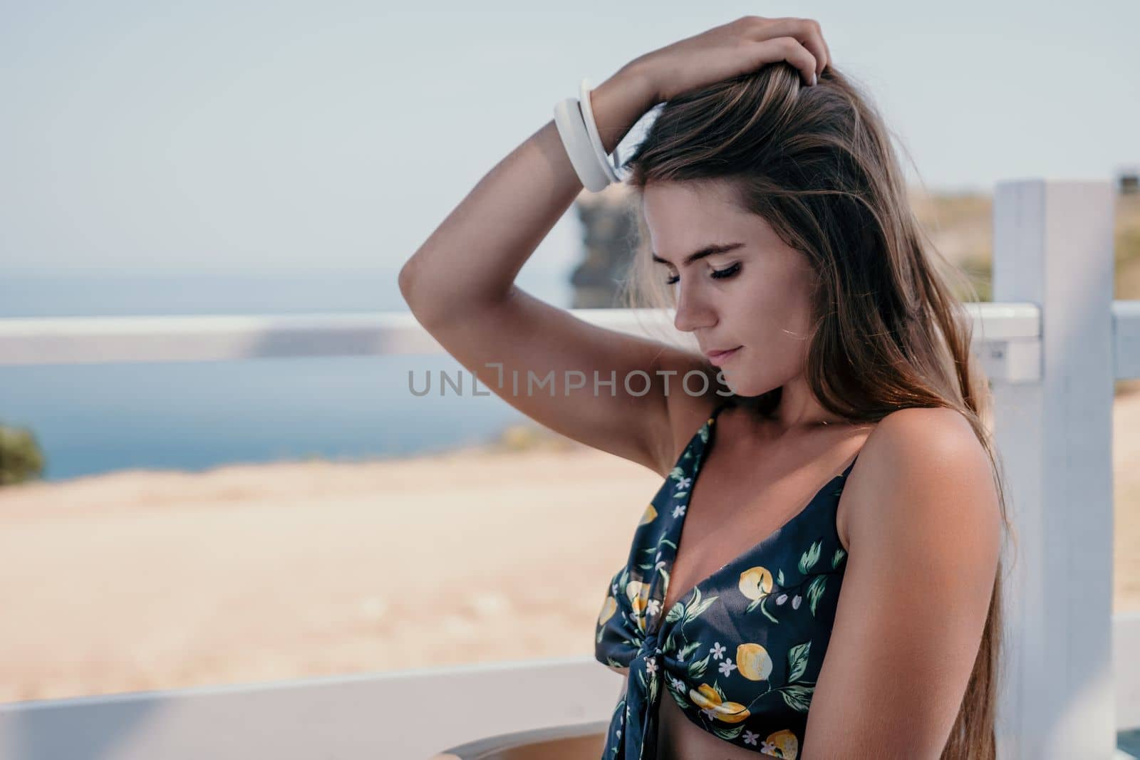 Happy woman portrait in cafe. Boho chic fashion style. Outdoor photo of young happy woman with long hair, sunny weather outdoors sitting in modern cafe