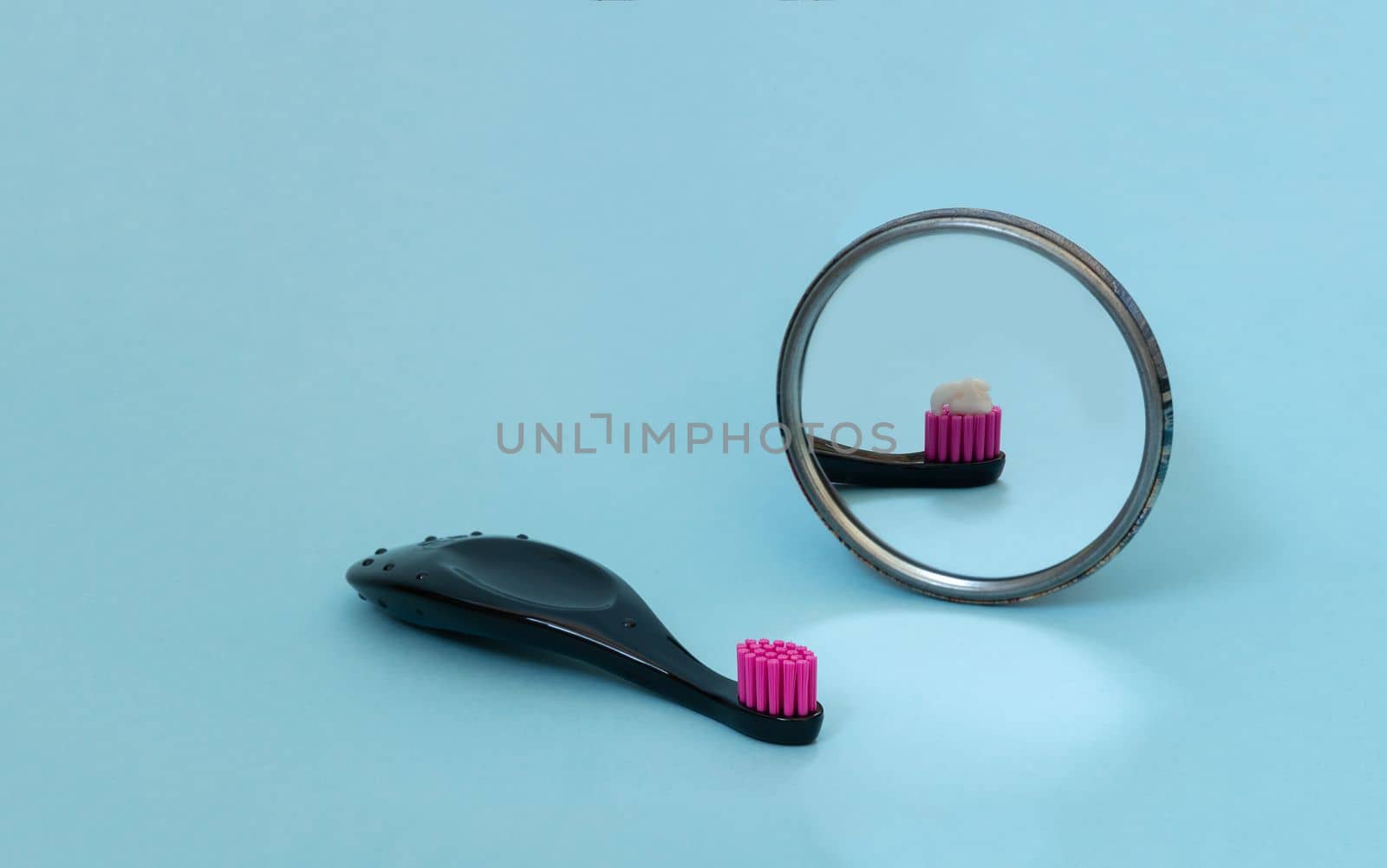 Kids toothbrush with toothpaste mirorr reflection. International day of dentist. Creative concept of daily morning routine. Copy space. by Ri6ka