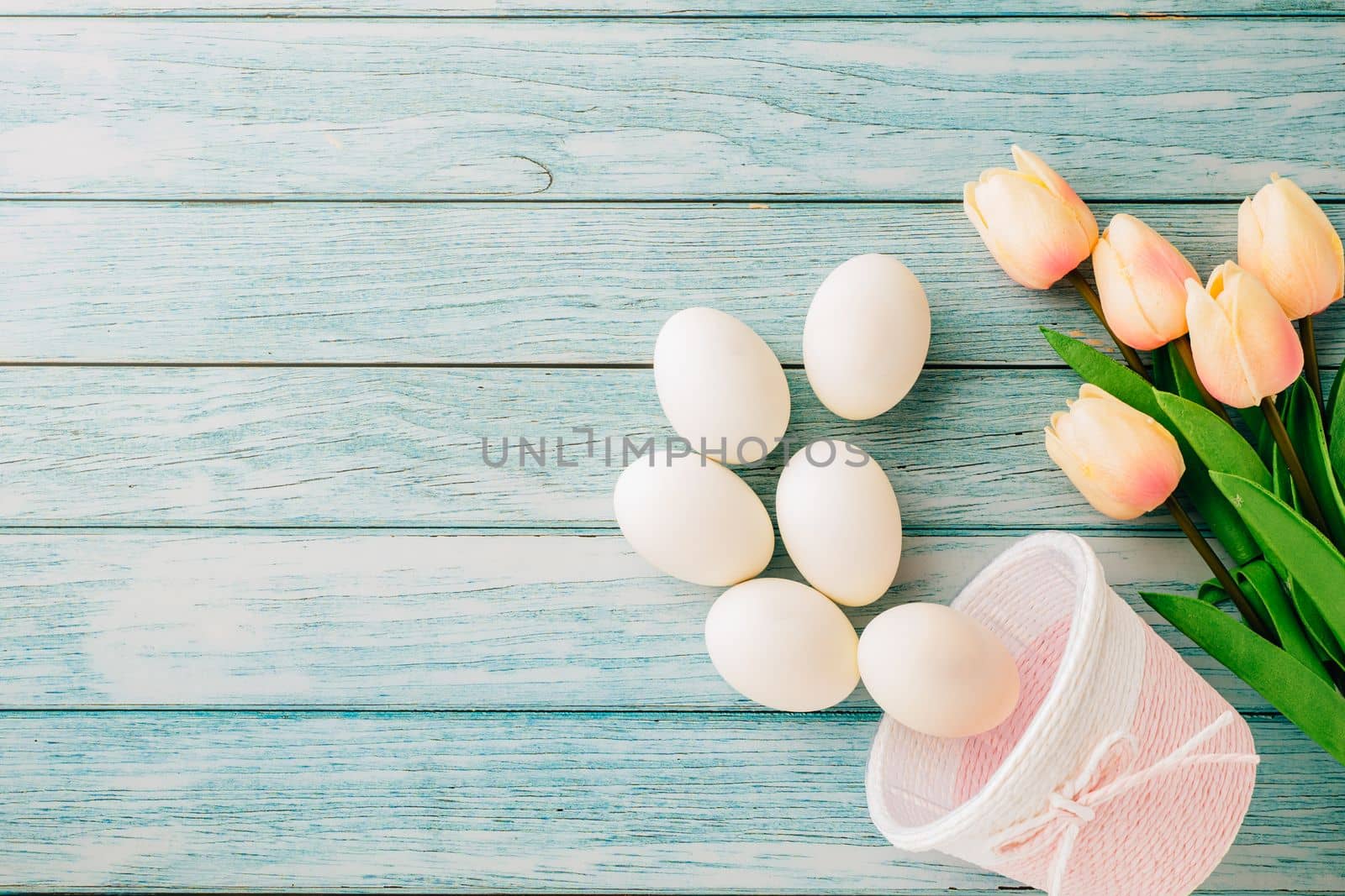 Happy Easter Day Concept. Top view of holiday banner background design white easter eggs and basket on blue wooden background with empty copy space, celebration greeting card