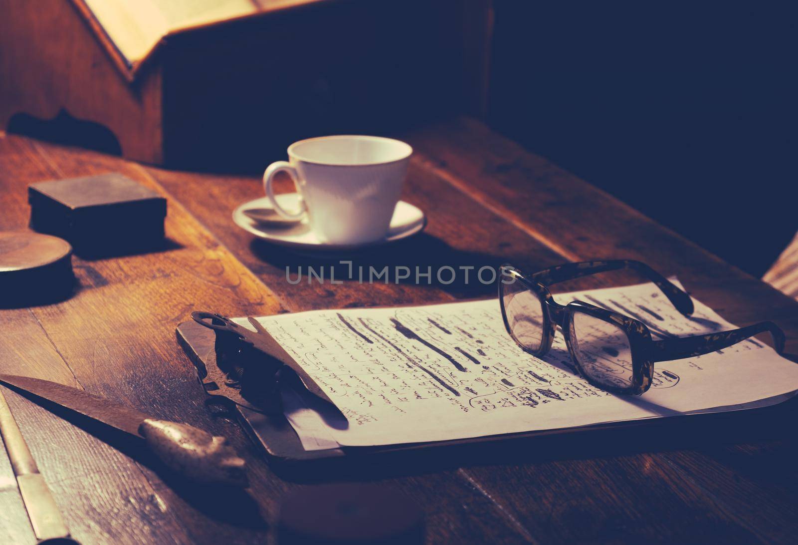 Detail Of A Writer Or Academic's Desk With Manuscript, Glasses And A Cup Of Tea