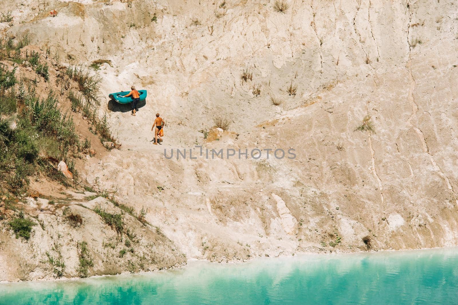 Vaukavysk chalk pits or Belarusian Maldives are beautiful saturated blue lakes.Two tourists pull a boat out of the water Belarus.