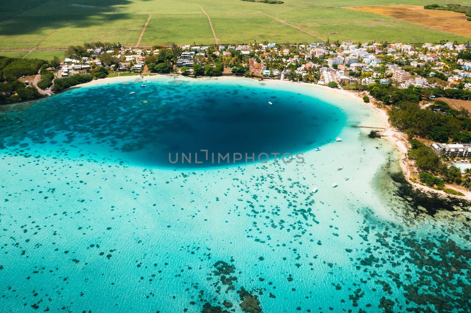 Aerial picture of the east coast of Mauritius Island. Beautiful lagoon of Mauritius Island shot from above. Boat sailing in turquoise lagoon by Lobachad