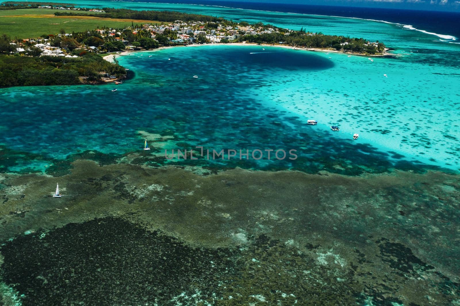 Aerial picture of the east coast of Mauritius Island. Beautiful lagoon of Mauritius Island shot from above. Boat sailing in turquoise lagoon