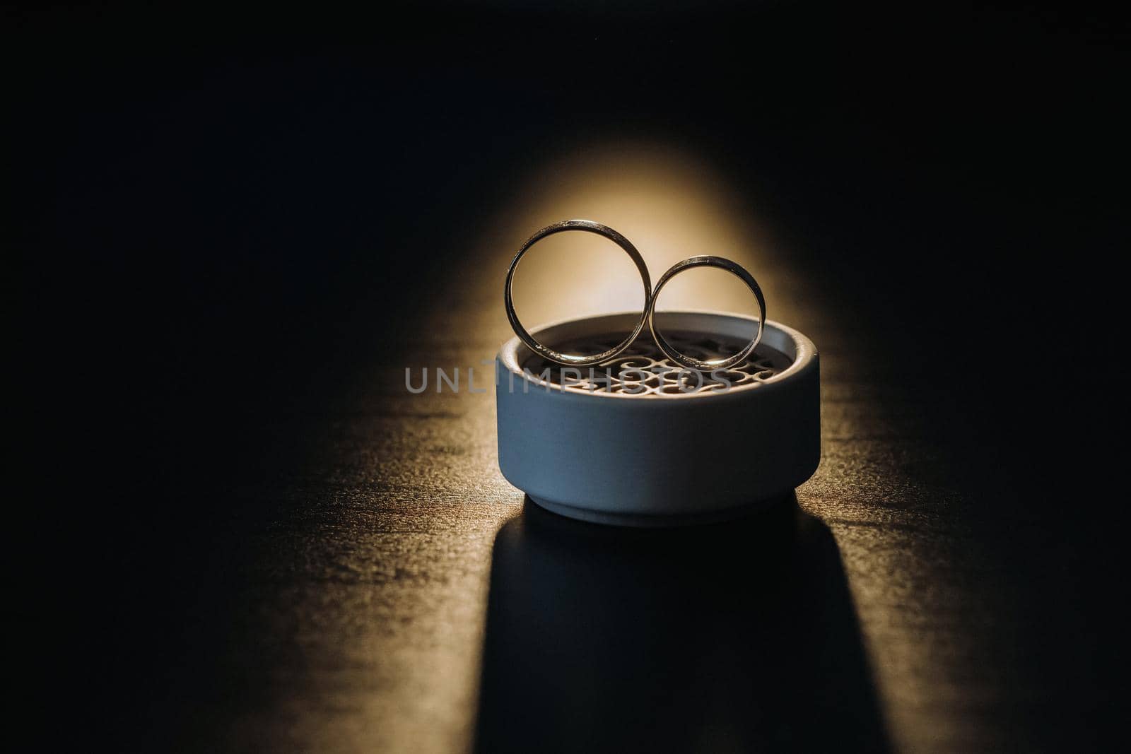 two gold wedding rings in a white box on a black background.