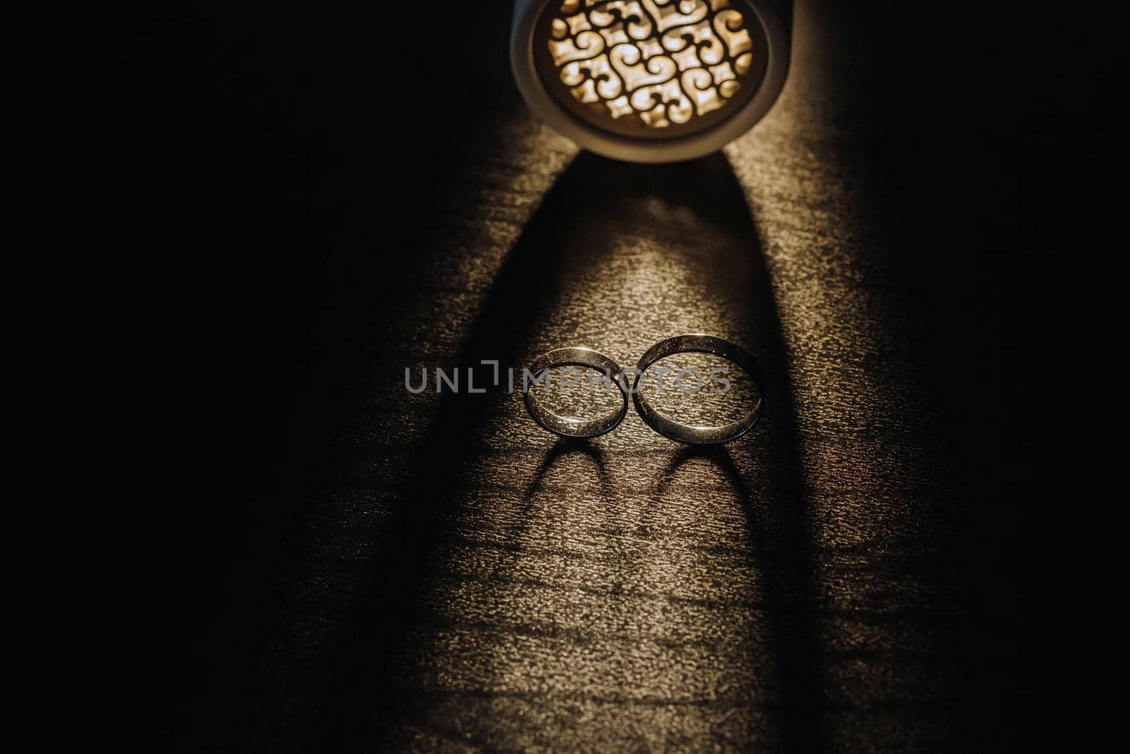 Close-up of two gold wedding rings on a black background.