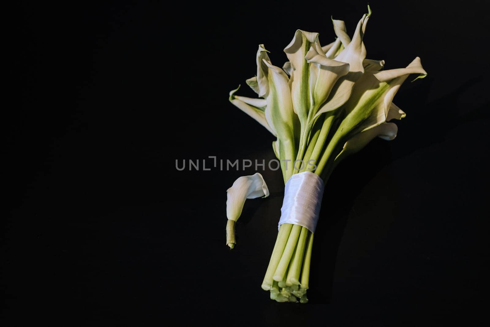 Wedding bouquet of white Calla lilies on a black background by Lobachad