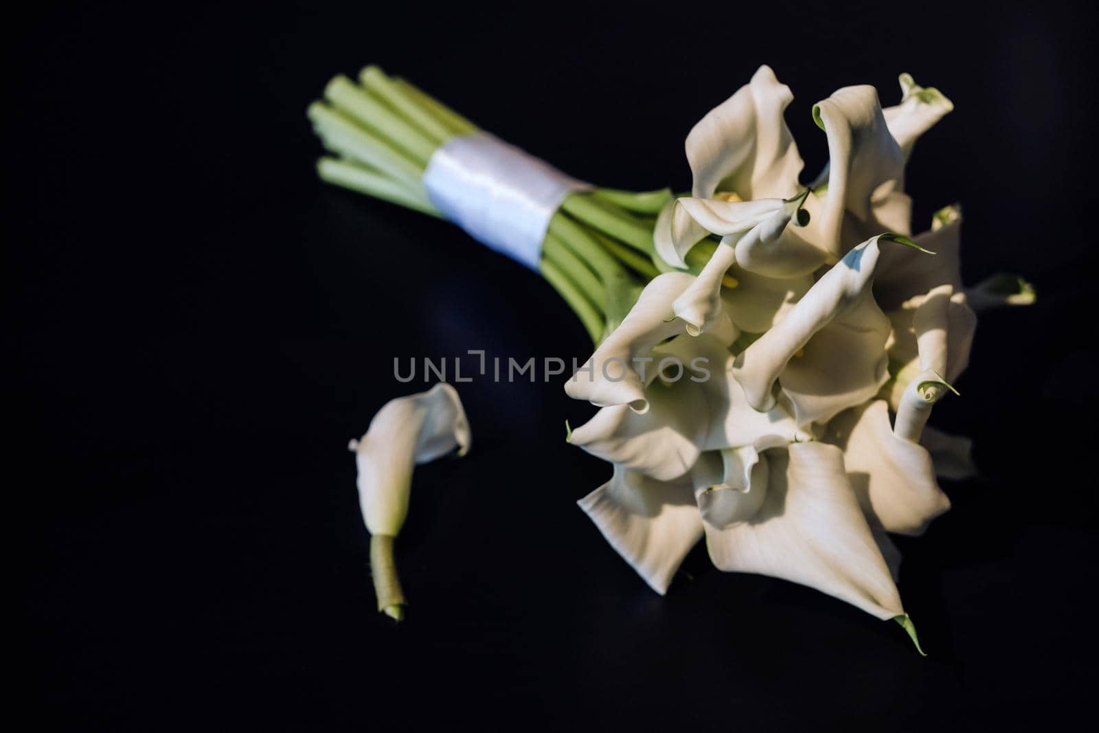 Wedding bouquet of white Calla lilies on a black background by Lobachad