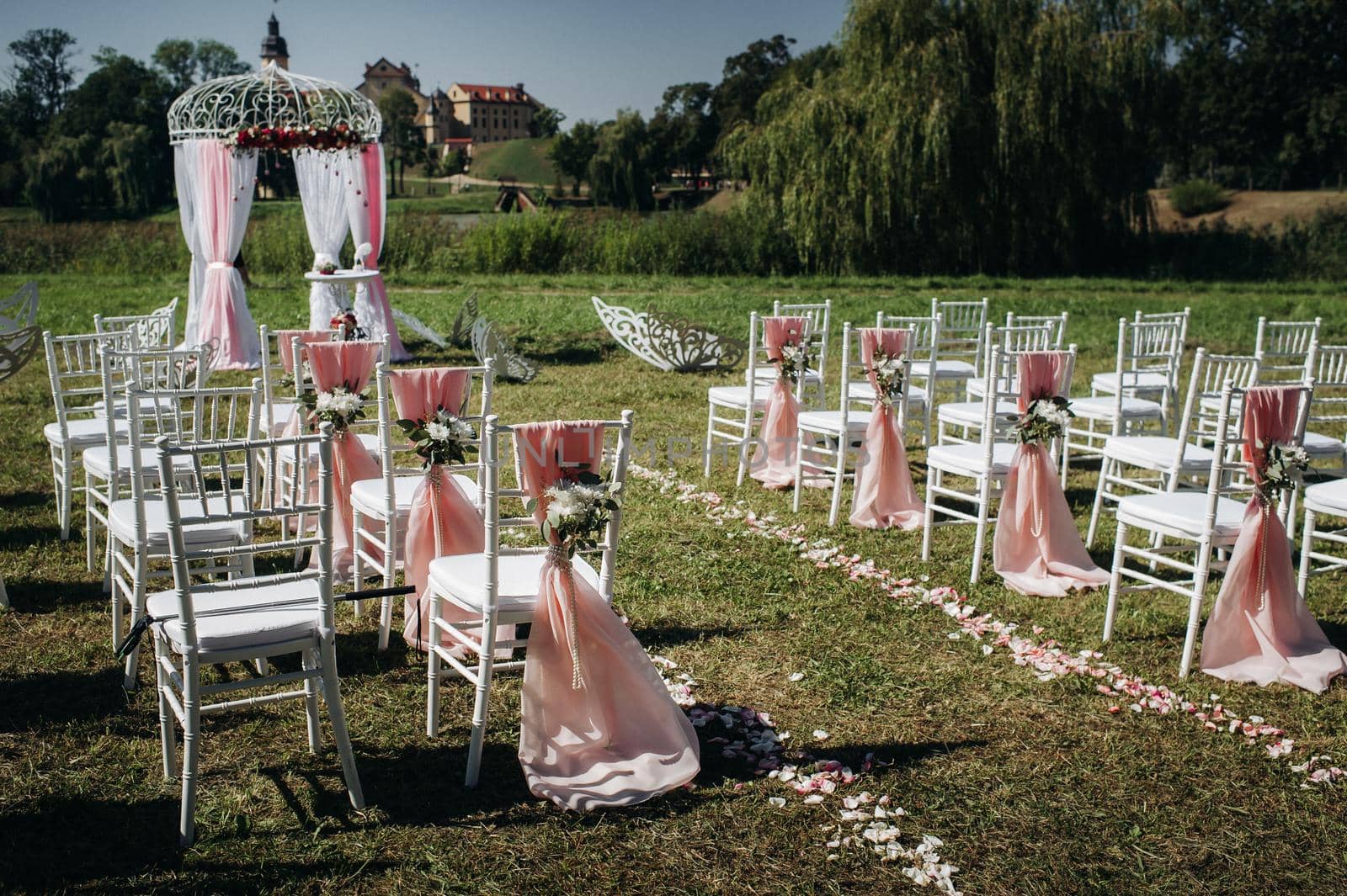 Wedding ceremony on the street on the green lawn.Decor with fresh flowers arches for the ceremony.