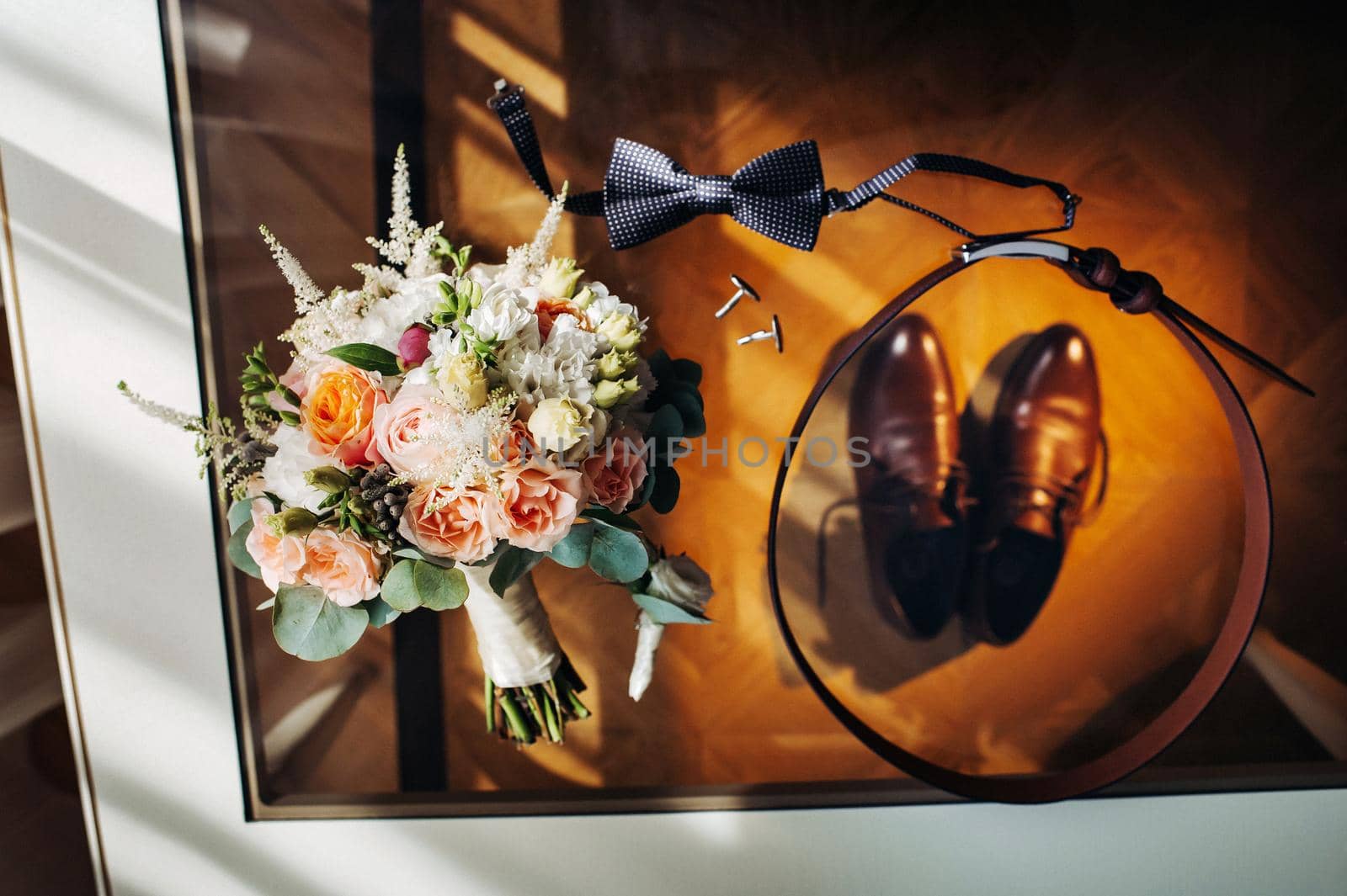 wedding bouquet with roses on the table and a boutonniere.The decor at the wedding.