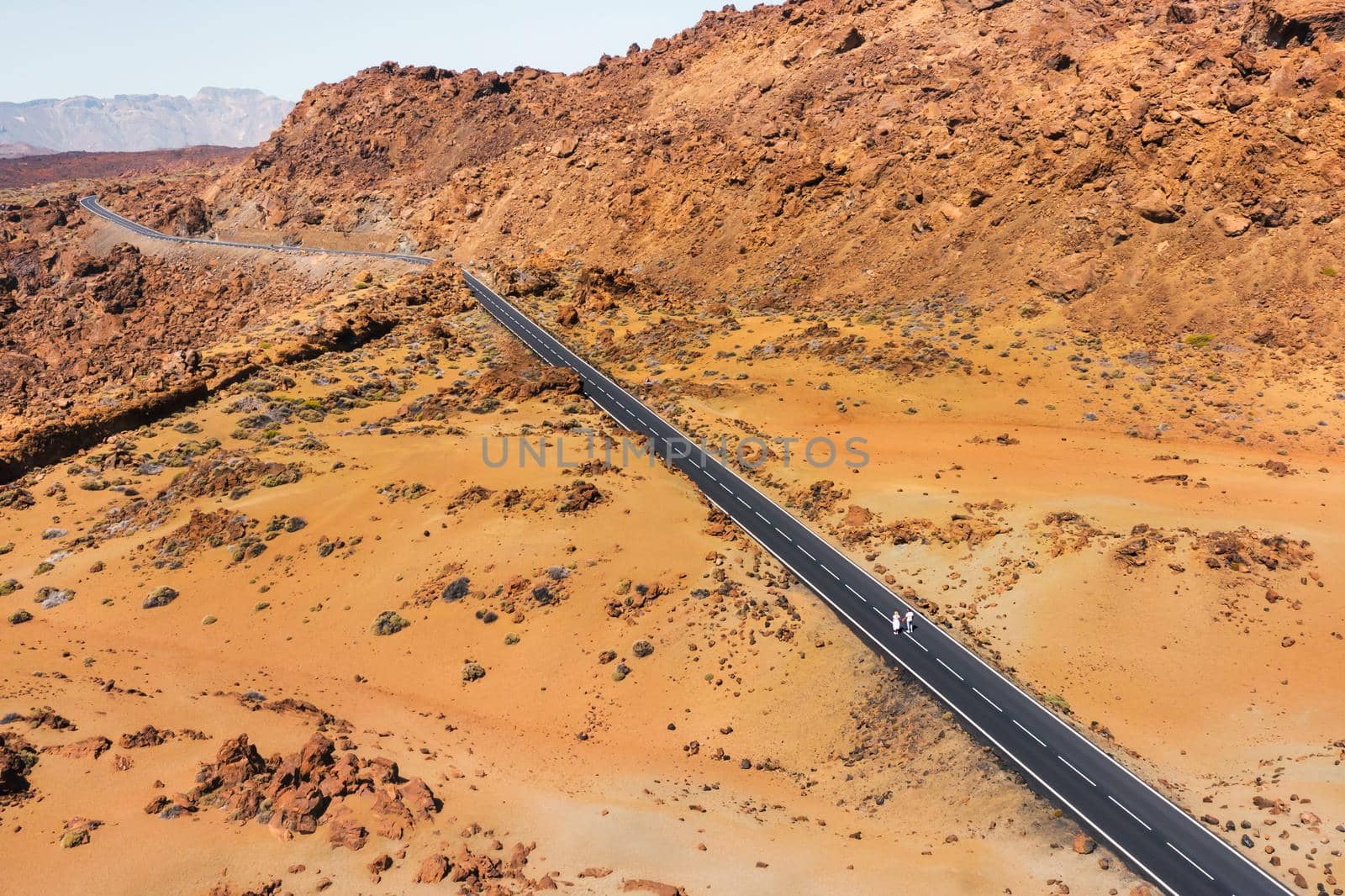 A couple in love walks along the road in the crater of the Teide volcano.Mars is the desert landscape of the red planet. Teide National Park. Tenerife, Canary Islands by Lobachad