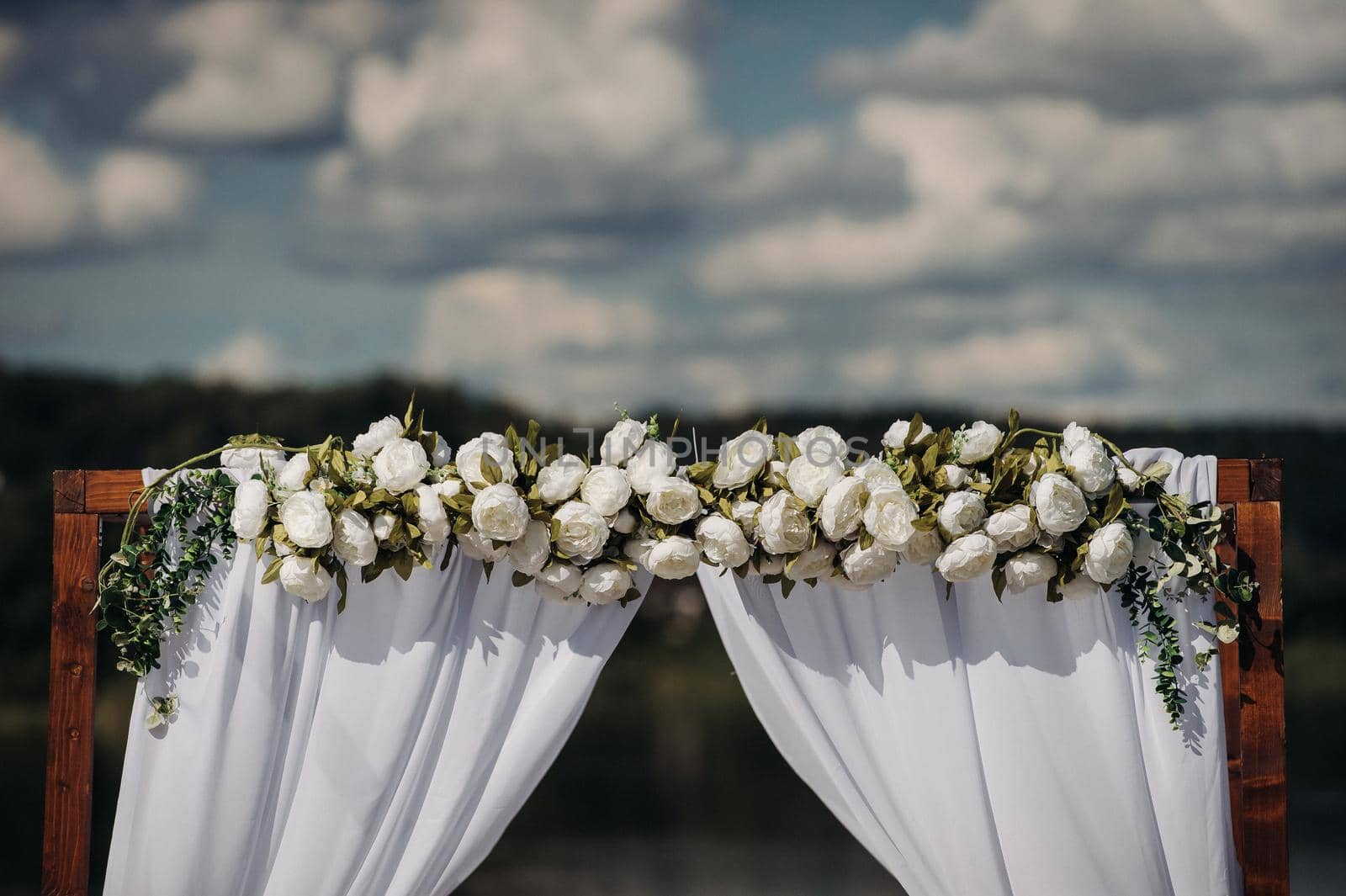 Wedding ceremony on the street on the green lawn.Decor with fresh flowers arches for the ceremony.