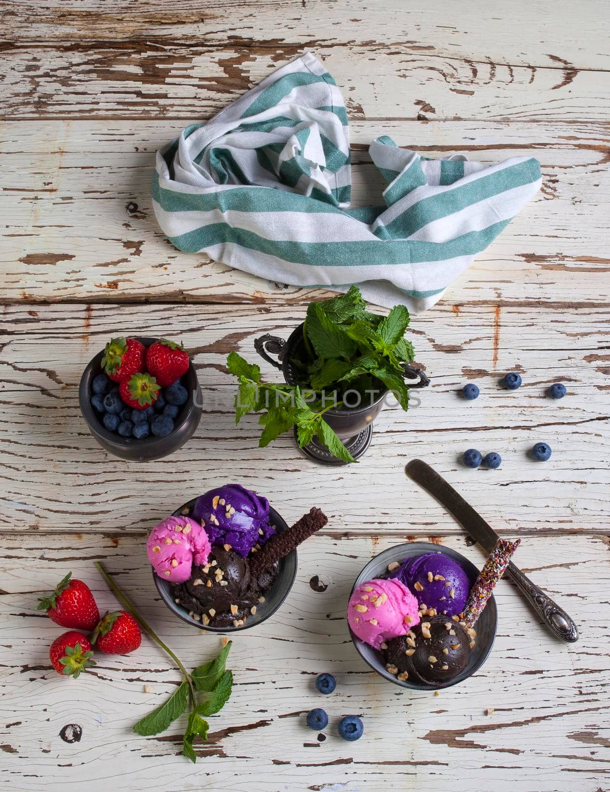 Variety of ice cream scoops in the bowls. Chocolate, strawberry and blueberry flavours