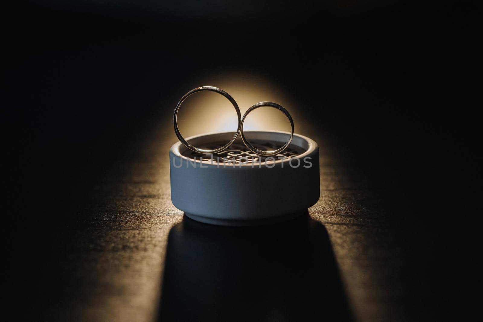 two gold wedding rings in a white box on a black background by Lobachad