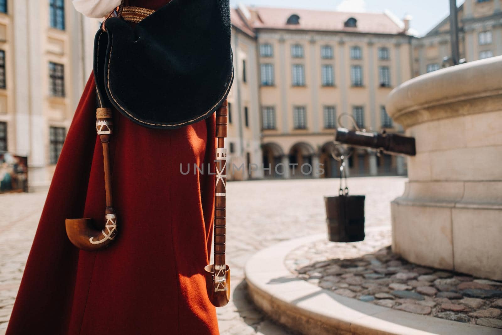 a man in an old red dress close-up on the square in the Nesvizh castle.Nesvizh castle, Belarus by Lobachad