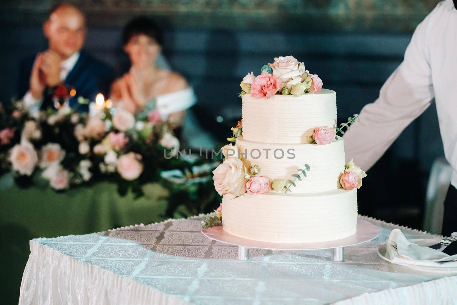 Elegant wedding cake at the wedding in three tiers.