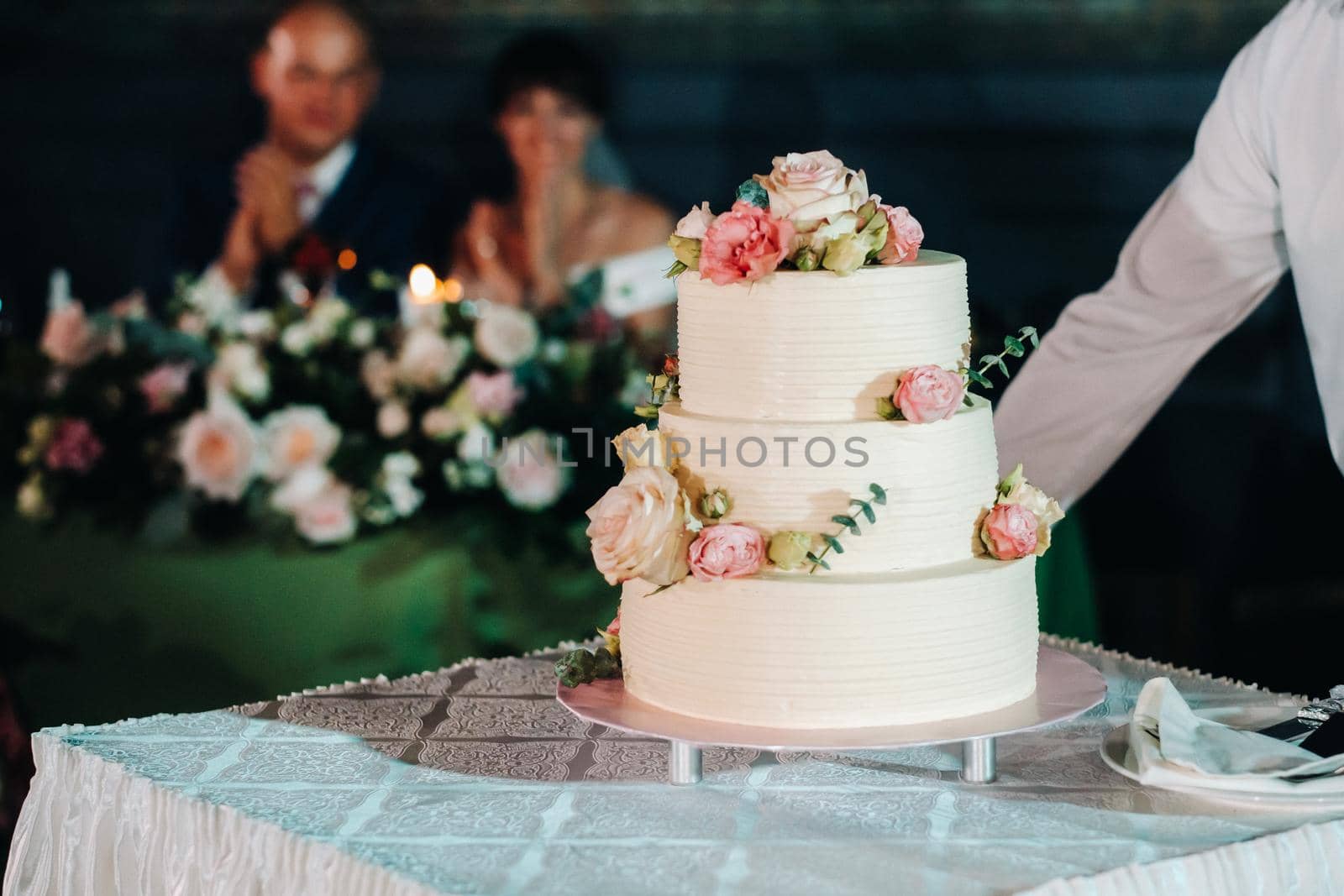 Elegant wedding cake at the wedding in three tiers.